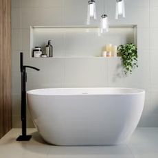 A freestanding bath with a freestanding black tap