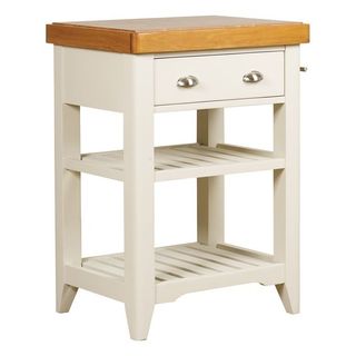 A wooden butchers block on a white wooden frame with open shelving