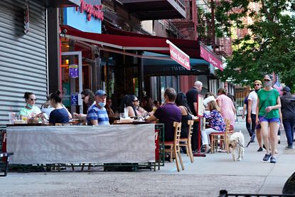 Customers are served at outside tables as the city moves into Phase 2 of re-opening following restrictions imposed to curb the coronavirus pandemic on June 24, 2020 in New York City