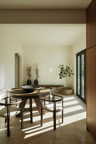 neutral dining room with round table and houseplants