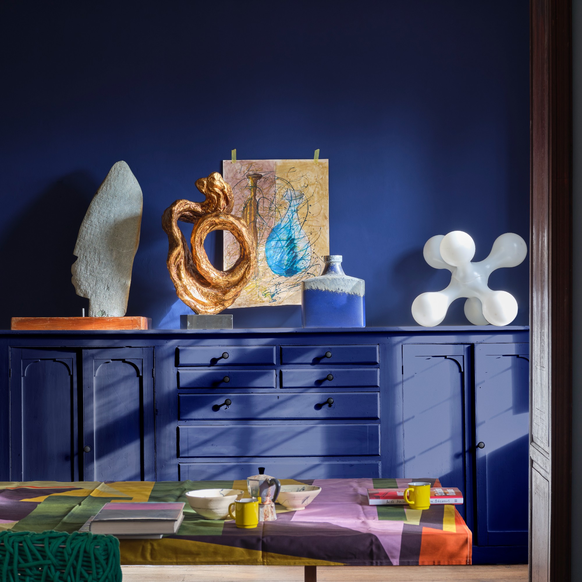 A small room colour drenched in Farrow & Ball's Blue Maize paint shade used on the walls and sideboard