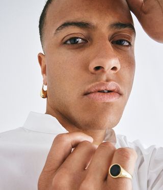 man's face wearing earring and ring