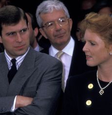 Prince Andrew folding his arms standing next to Sarah Ferguson