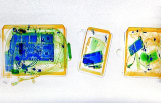 An X-ray image showing bags being scanned at an airport