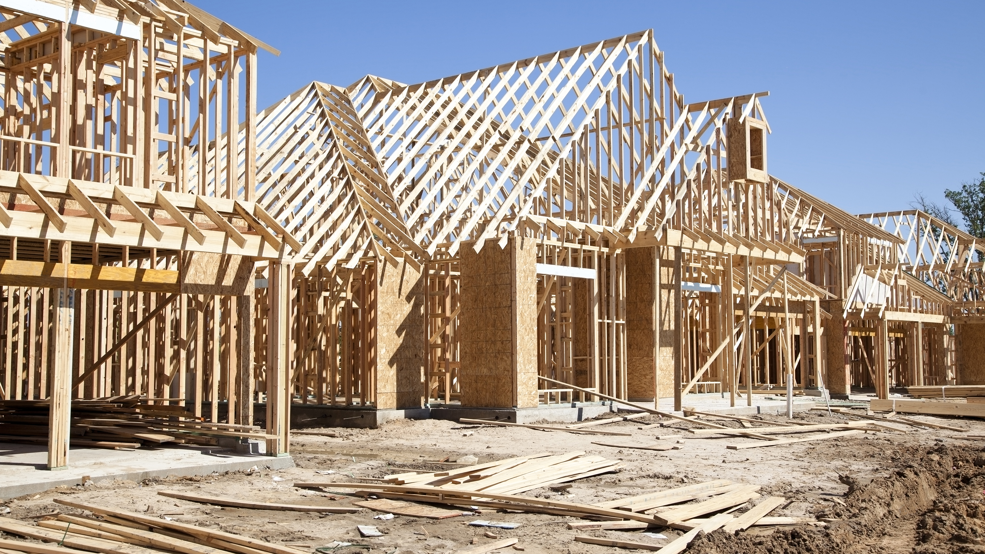 several timber frame houses in the process of being built on a building site