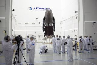 Members of the news media are given an opportunity for an up-close look at the TDRS-L spacecraft undergoing preflight processing inside the Astrotech payload processing facility in Titusville ahead of the satellite's January 2014 launch.