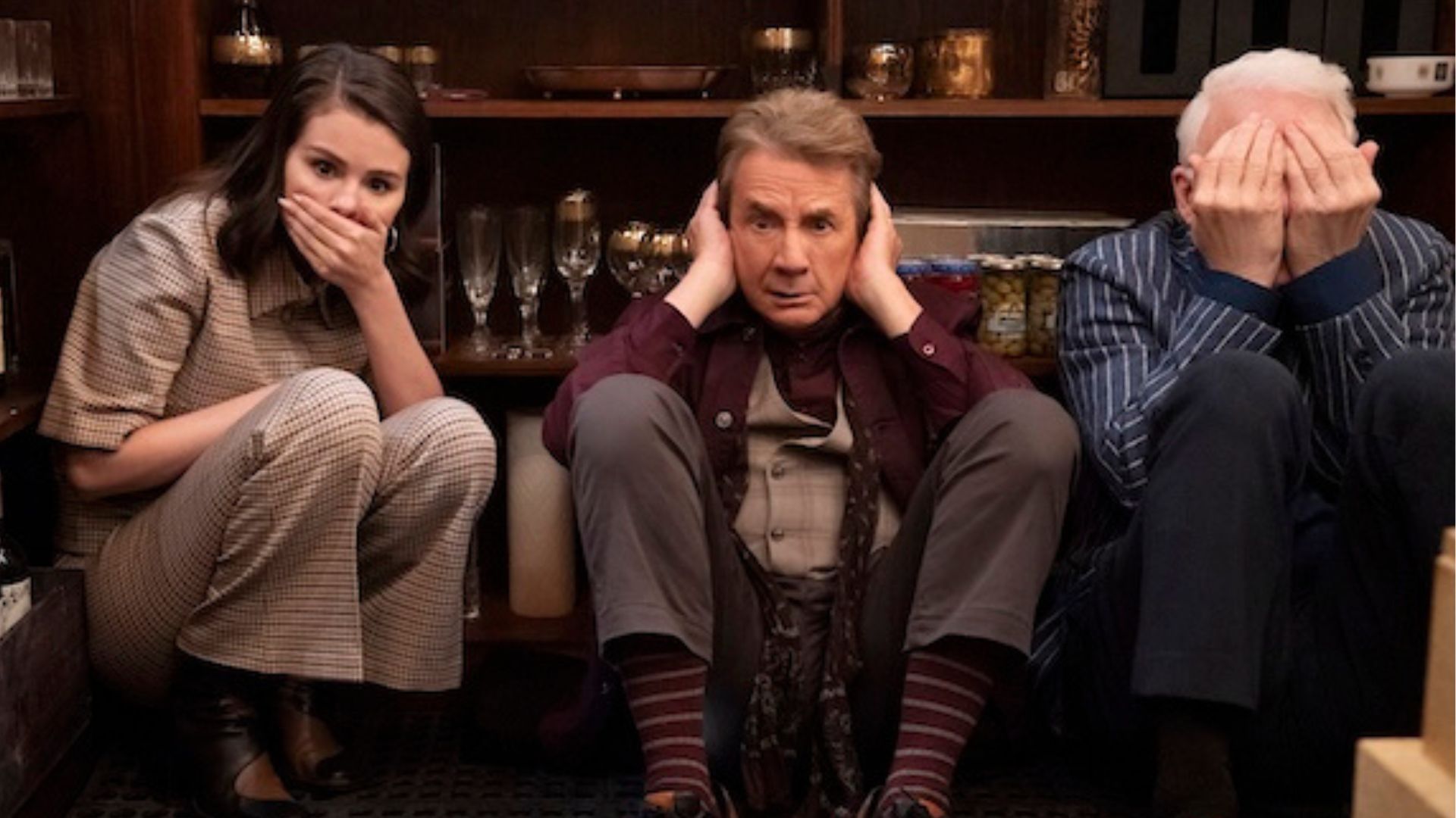 Selena Gomez, Martin Short and Steve Martin re-enact the hear no evil, see no evil, speak no evil poses on the floor of a wine cellar
