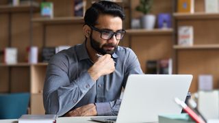 Homme regardant une vidéo sur son ordinateur portable dans un bureau