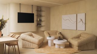 Living area with cream textured walls, minimalist shelving built into a nook, cream fabric armchairs and white ribbed coffee tables