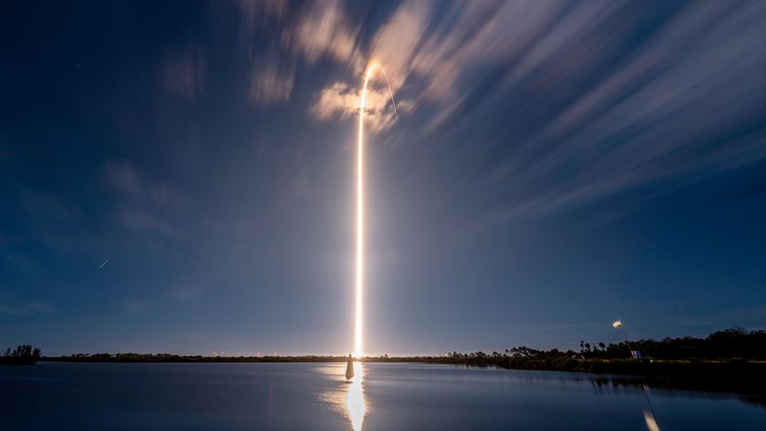 a timelapse photo of a rocket launch causes the appearance of a bright beam of light extending from the ground into the night sky