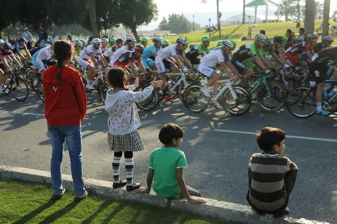 Young spectators experience the thrill of the peloton speeding past