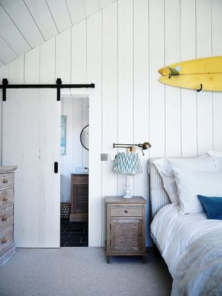 Coastal small master bedroom with shiplap paneling and sliding door