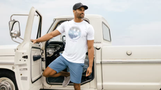 Man standing in front of a truck wearing a travismathew tshirt