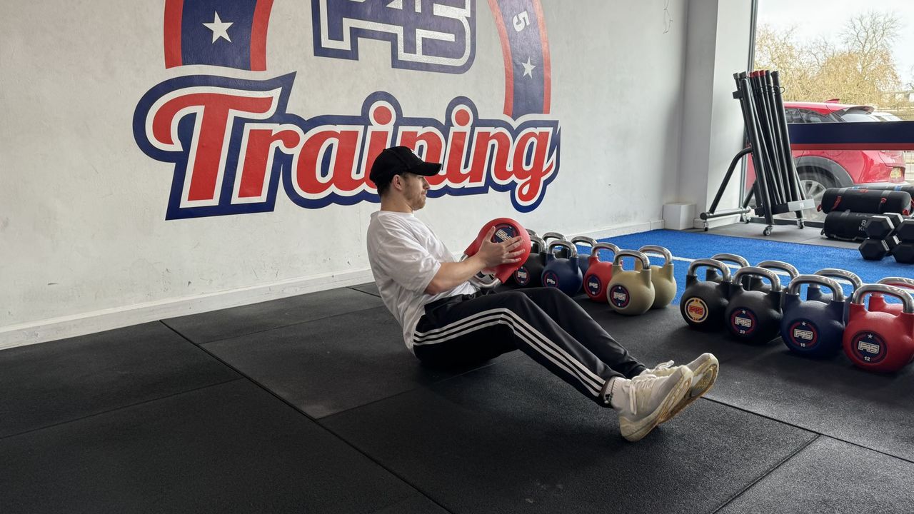 F45 personal trainer demonstrates a russian twist