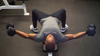 man in the gym performing a dumbbell fly