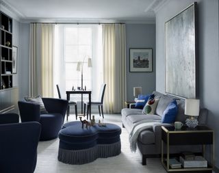 blue living room with ottoman by Gunter & Co