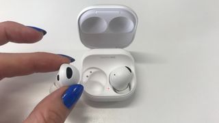 Samsung Galaxy Buds 2 Pro held in a hand on white background