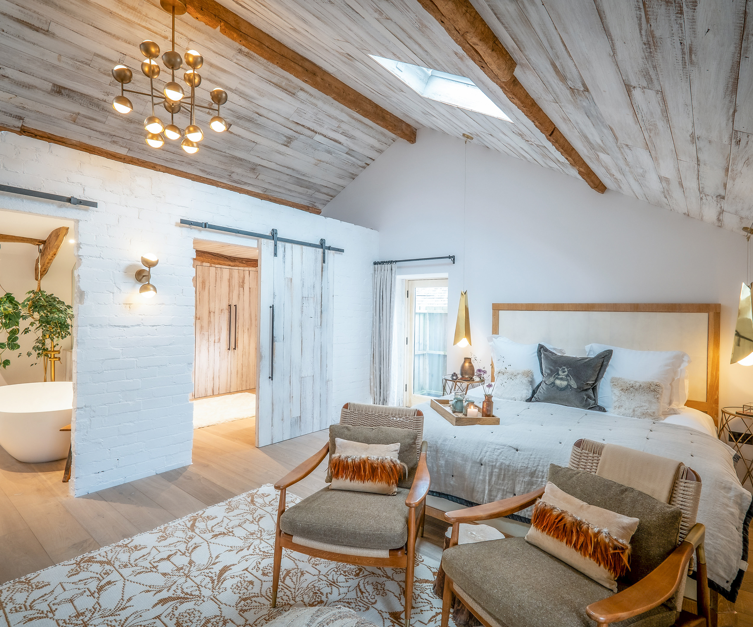 large master bedroom with en suite and barn doors with timber cladding on ceiling