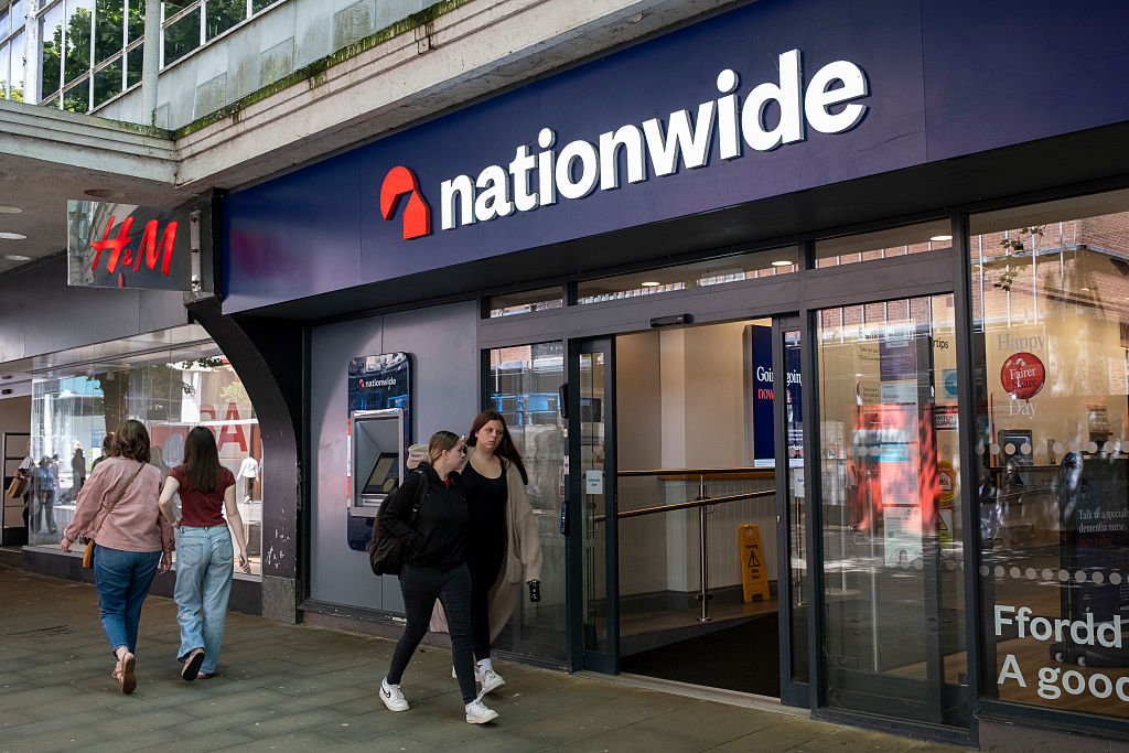 Two people walk past branch of Nationwide