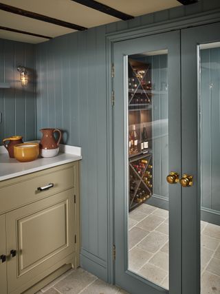 A stylish utility room leading to a wine cellar through glass double doors