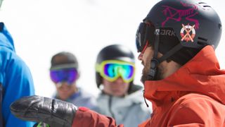 Three skiers wearing helmets