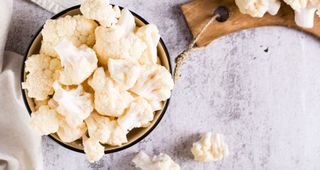 Cauliflower florets in bowl on marble counter