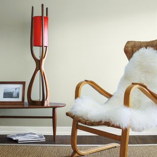 living area with white wall and white dove and woodden floor and arm chair