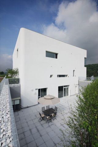 rounded house in South Korea is a white boxy composition with curved corners by architect ChoHelo