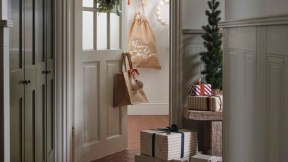 An entryway with an open front door, oiles of wrapped gift boxes surrounding it 