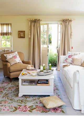 warm neutral living room with country patterns and doors open leading onto a garden