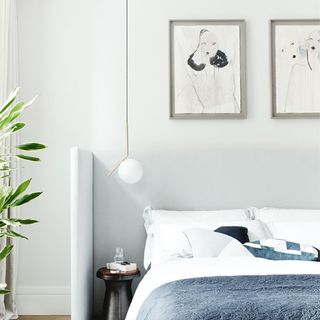 bedroom with white wall and frames on wall