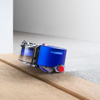 Dyson 360 Heurist robot vacuum cleaner moving from carpet to hard wood floor
