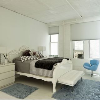bedroom with swan chair rug and white walls