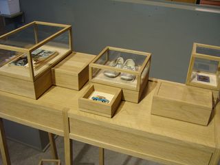 Wooden table with glass display boxes containing souvenirs