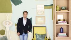 Nathan Turner standing in front of a large mural next to yellow chair and pink bookcase