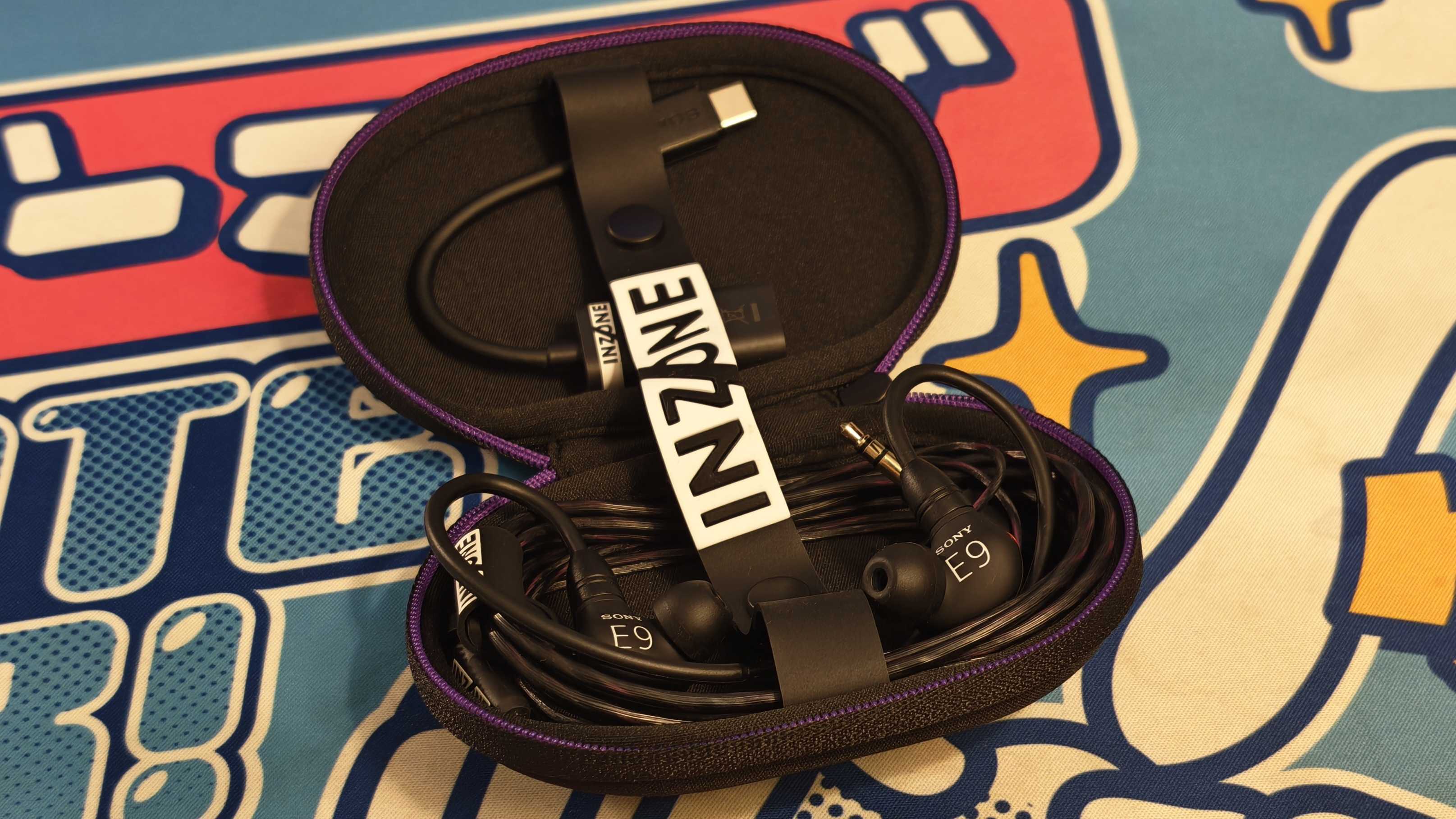 The Sony Inzone E9 gaming earbuds on a colorful desk mat.