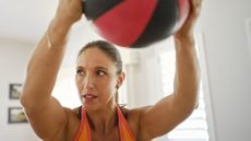 Woman holding medicine ball at head height
