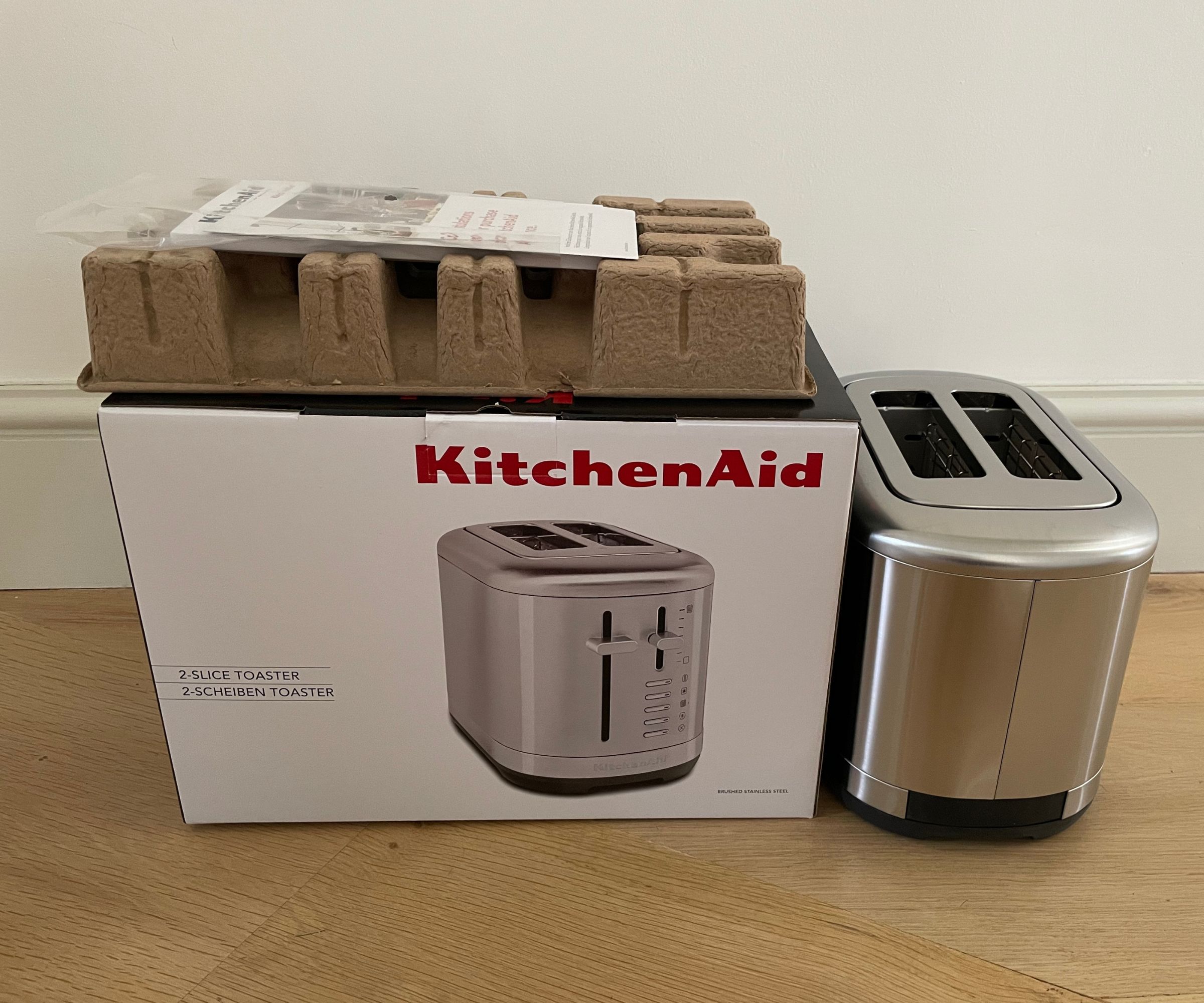 KitchenAid 2 Slice Manual Lift Toaster unboxed with the packaging at the side of it