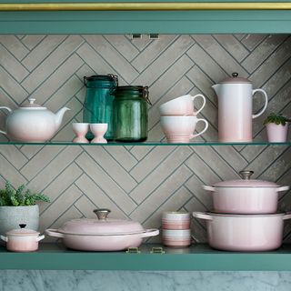 kitchen wall in grey and shelves having shell pink kitchen dishes
