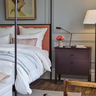 how to decorate a guest bedroom, four poster bed, small chest of drawers, grey walls, artwork