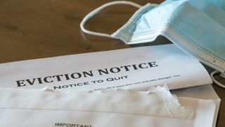 open eviction notice on table with surgical mask lying nearby