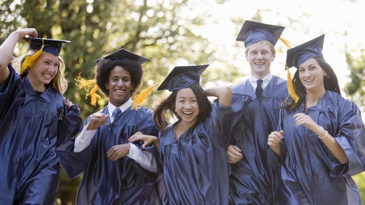  A group of graduates wearing caps and gowns on their graduation day. 