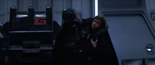 a man in a black cloak helps another man in black armor to walk