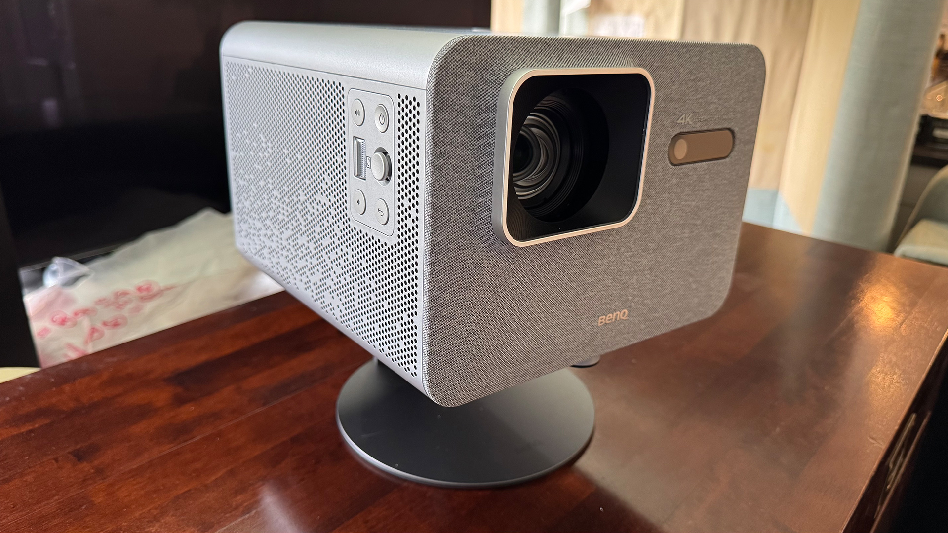 BenQ TK705i home cinema projector on stand on wooden tabletop