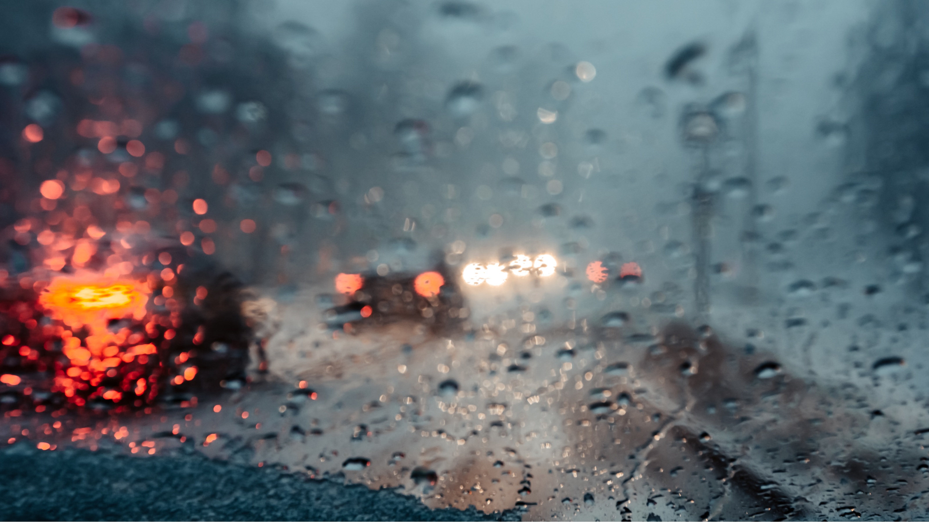 Looking through a rain-splattered windshield while driving in a storm.