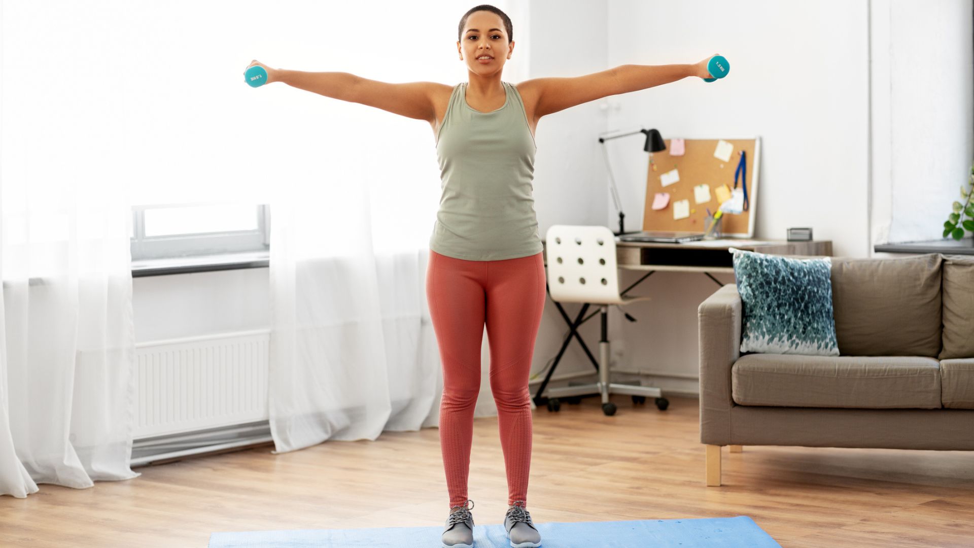 woman does lateral shoulder raise exercise at home