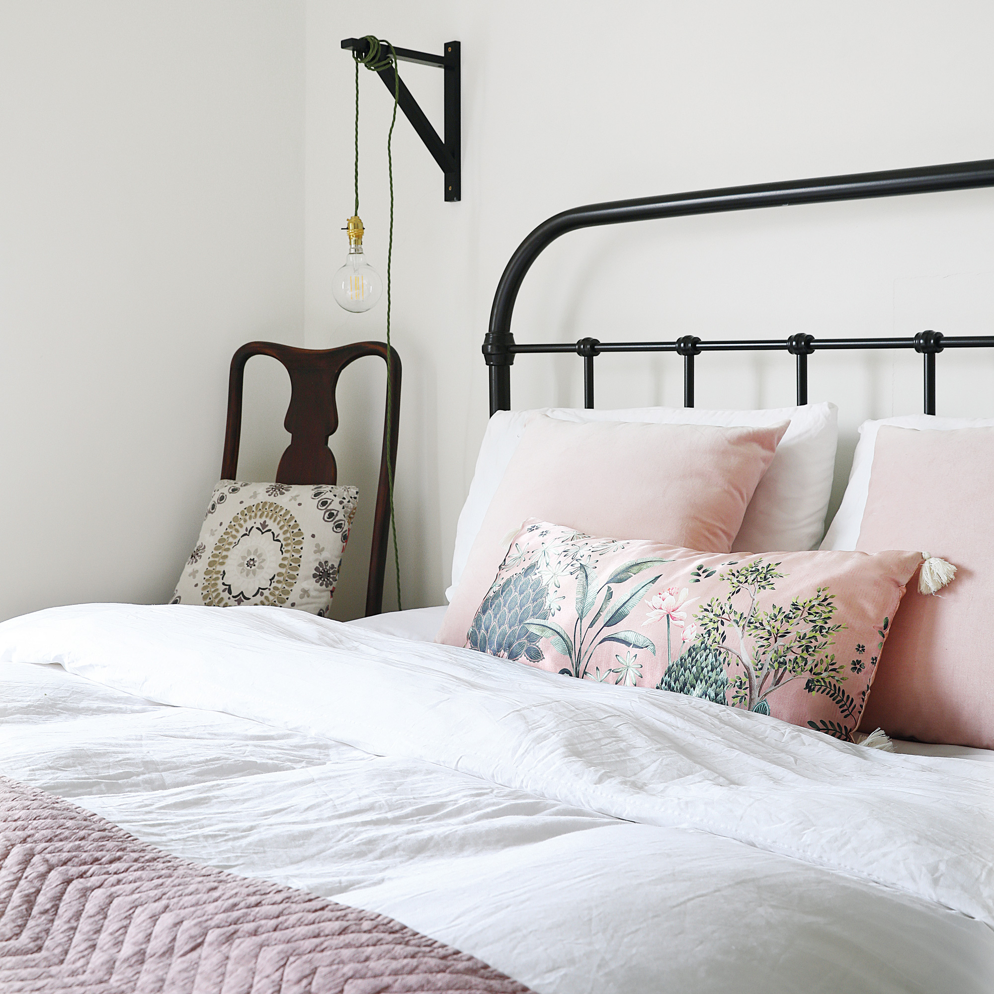 Victorian property revamp bedroom with black metal bed and pink and white bedlinen