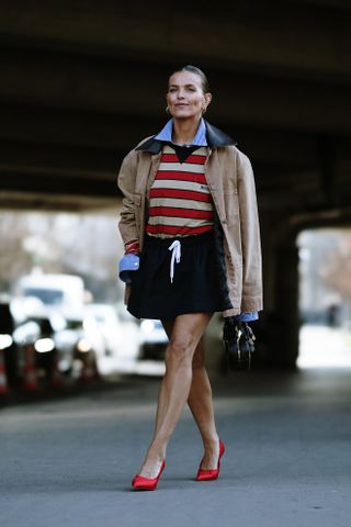 Woman in polo top and skirt.