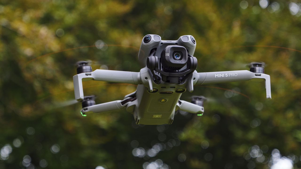 DJI Mini 5 Pro in flight with trees in the background