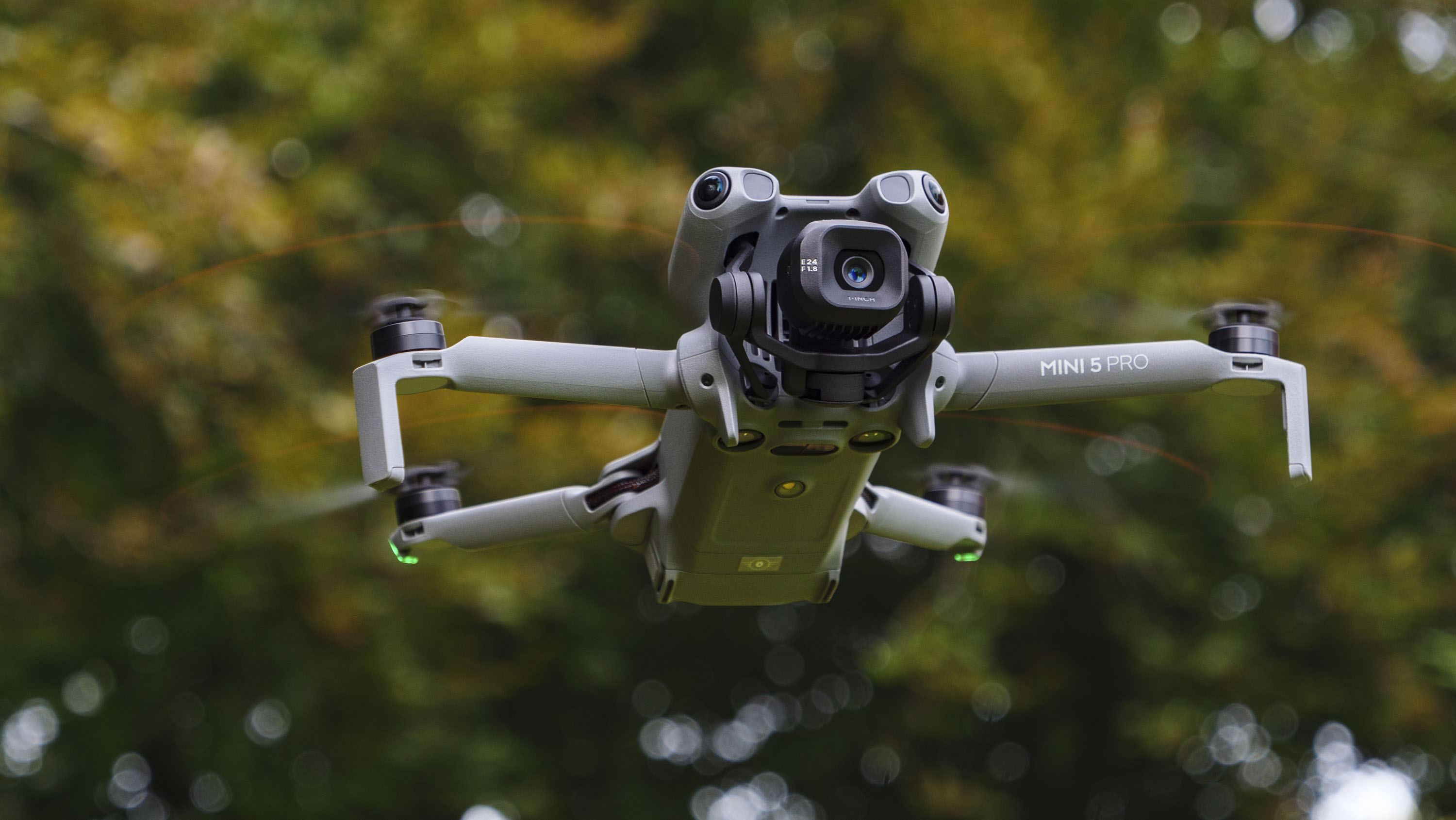 DJI Mini 5 Pro in flight with trees in the background